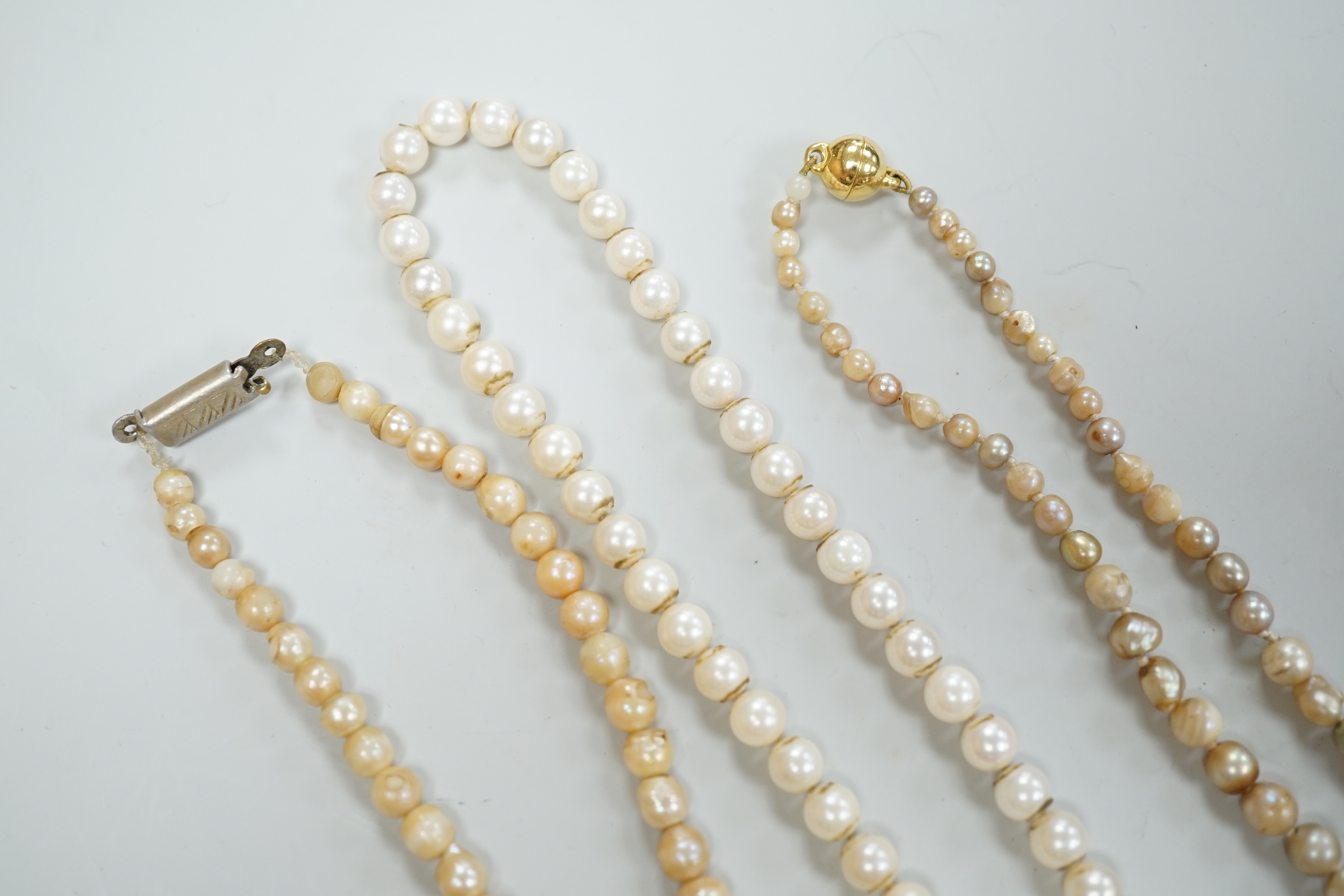 Three assorted single strand cultured pearl necklaces, longest 58cm.